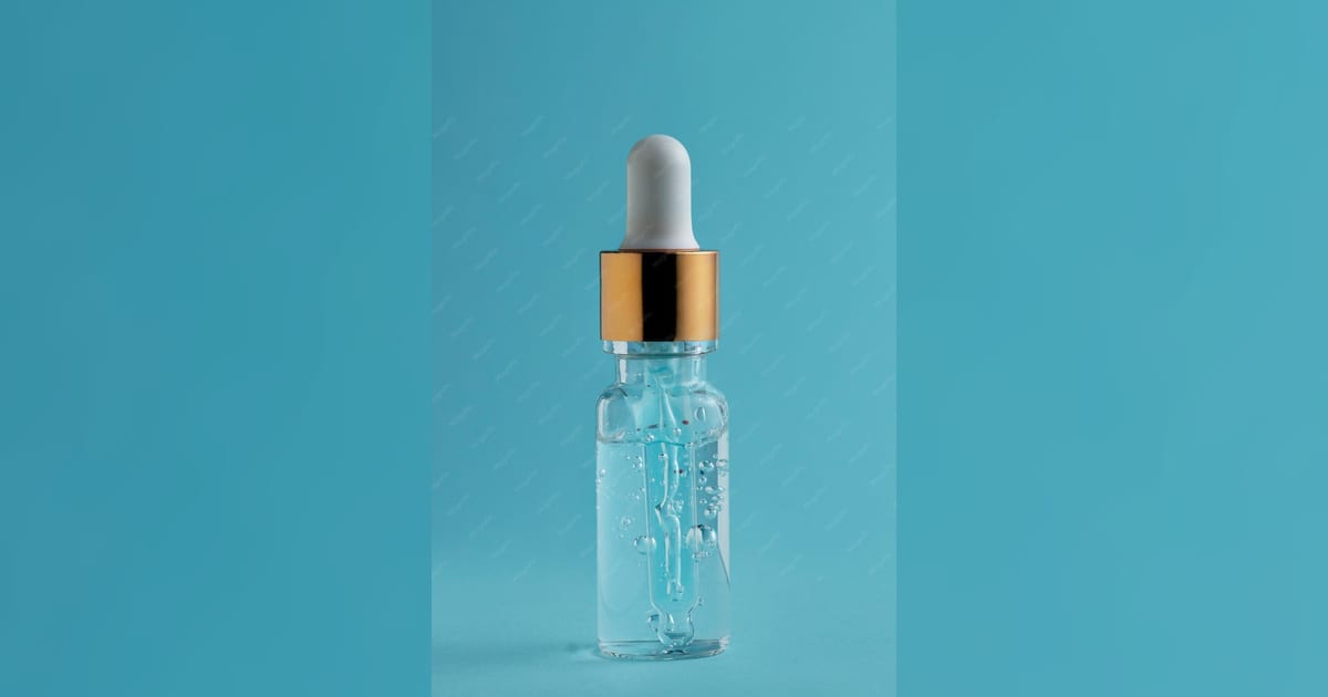 Frasco de sérum sobre superfície clara em foto de skincare.
