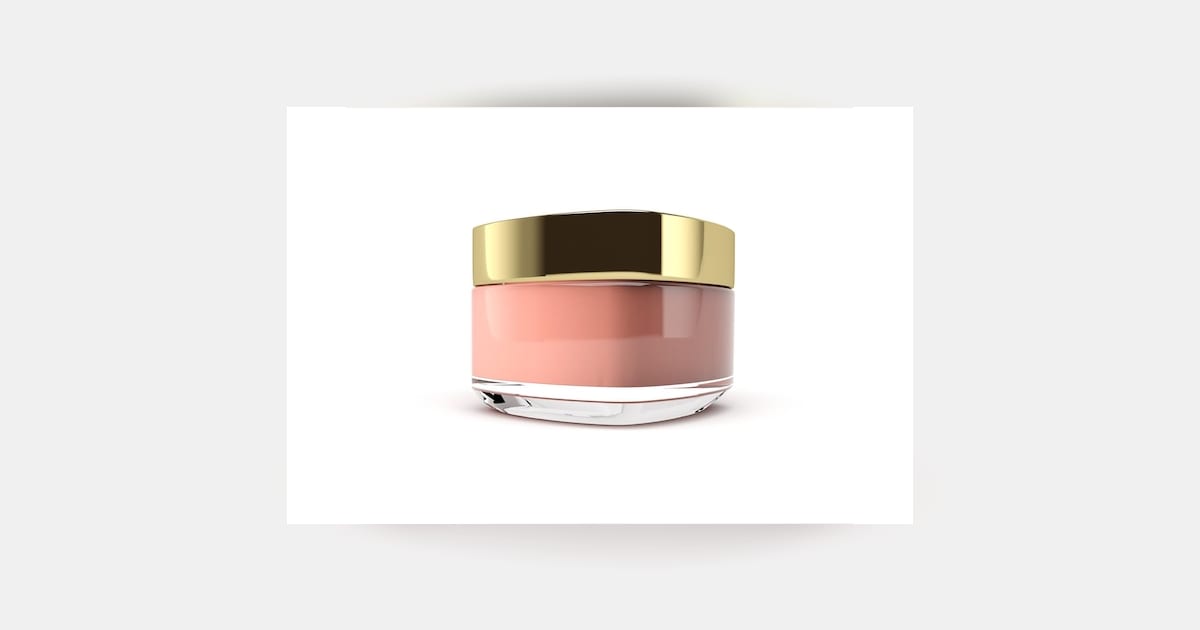 Pote de creme rosa com tampa dourada em composição de skincare sem pessoas.